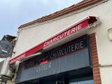 une enseigne sur le mur d'un immeuble où l'on peut lire « charquetrie »