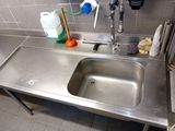 a sink in the kitchen with a lot of cleaning supplies on the counter