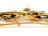 a gold bird brooch on a branch of a tree
