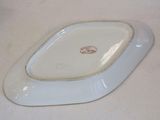 a small white plate with a brown design on it