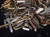 many different types of knives on a black table