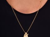 une femme portant un collier en or orné d'un petit lapin