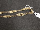 un bracelet en chaîne d'or auquel est attachée une étiquette