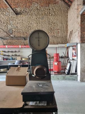 une grande horloge posée sur une table dans un entrepôt