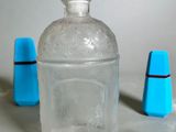 a clear glass bottle with a blue stopper on it