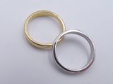 two gold and silver rings on a white surface