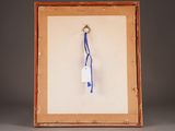 an old picture of a blue and white keychain hanging from a wooden frame