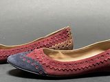 pair of red and blue shoes with holes on them on a gray surface