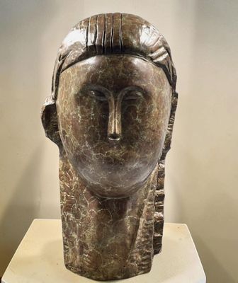 sculpture of a woman ' s head on a pedestal in a museum