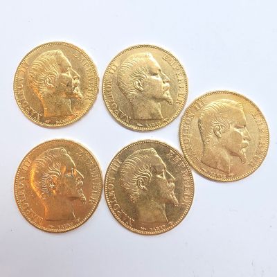 cinq souverains d'or de tailles et de formes différentes sur un fond blanc