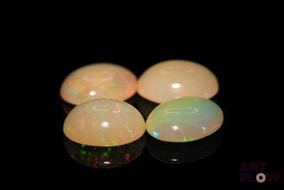 four white oplites are arranged in a row on a black surface