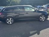 the car is parked in the parking lot near the trees