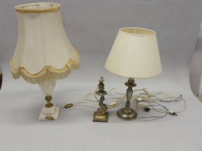Deux lampes et un abat-jour sont posés sur une table.