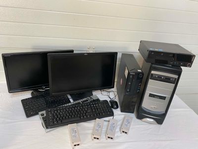 three computer monitors, a keyboard, and a monitor on a table