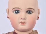 a doll with a bald head and a red bow tie