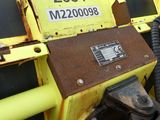 a close up of a yellow and black machine in the grass