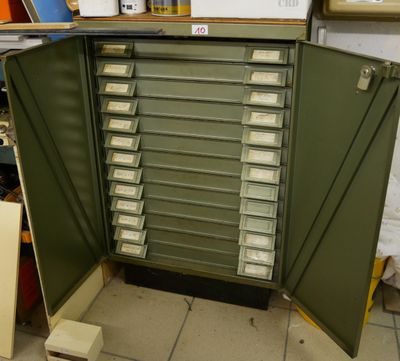une armoire verte avec de nombreux tiroirs à l'intérieur