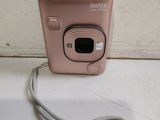 a pink camera sitting on a counter with a cord attached to it
