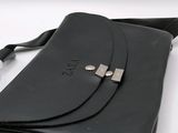 a black leather bag with a metal clasp on it