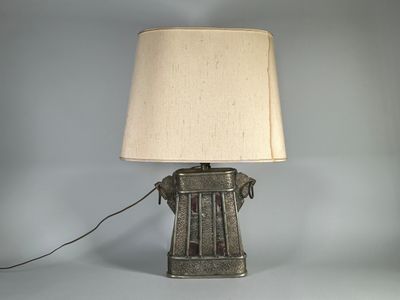 une lampe à l'ancienne surmontée d'un abat-jour blanc