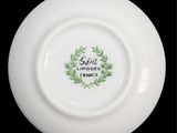 a white plate with a green wreath on it