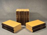 trois livres sont empilés sur une surface grise