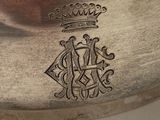 an antique silver plate with a crown on it on a table