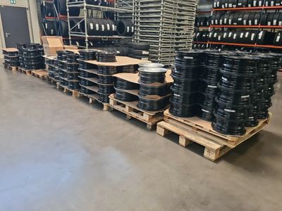 Un tas de pneus est empilé sur des palettes dans un entrepôt