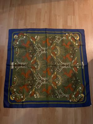 une photo d'une écharpe verte et bleue posée sur un parquet