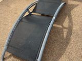 un fauteuil noir posé à même le sol devant une table et des chaises