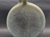 a vase that is sitting on a table with a gray background
