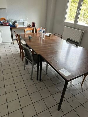 un sol carrelé dans une cuisine où se trouvent une table et des chaises