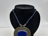 un collier orné d'une pierre bleue sur un mannequin noir