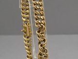 a close up of a gold bracelet on a clear stand