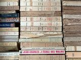 many books stacked on top of each other on a shelf