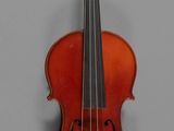 un vieux violon posé sur une table près d'un mur gris