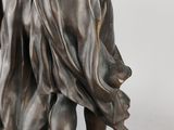 bronze statue of a woman holding a basket of flowers on a base