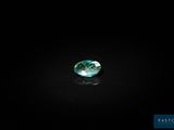 a green and white diamond on a black surface