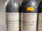 three bottles of red wine are lined up on a table