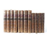 several old books lined up in a row on a white surface