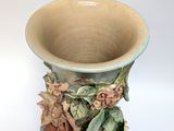 a blue vase with flowers and leaves on it