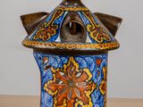 a blue and orange vase with a birdhouse on it