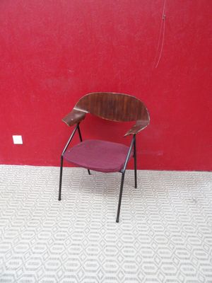 une chaise rouge posée devant un mur rouge