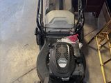 une image d'une tondeuse à gazon garée dans un garage