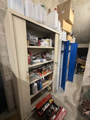 un homme debout devant une armoire contenant des outils