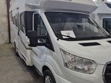 deux camping-cars blancs garés dans un grand entrepôt