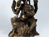 bronze statue of a woman sitting on a rock with a bird in her hand