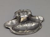 a silver plate with a spoon and spoon rest on it