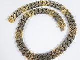 a close up of a gold and black necklace on a white surface