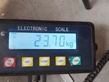 an electronic scale that is on the ground next to a telephone